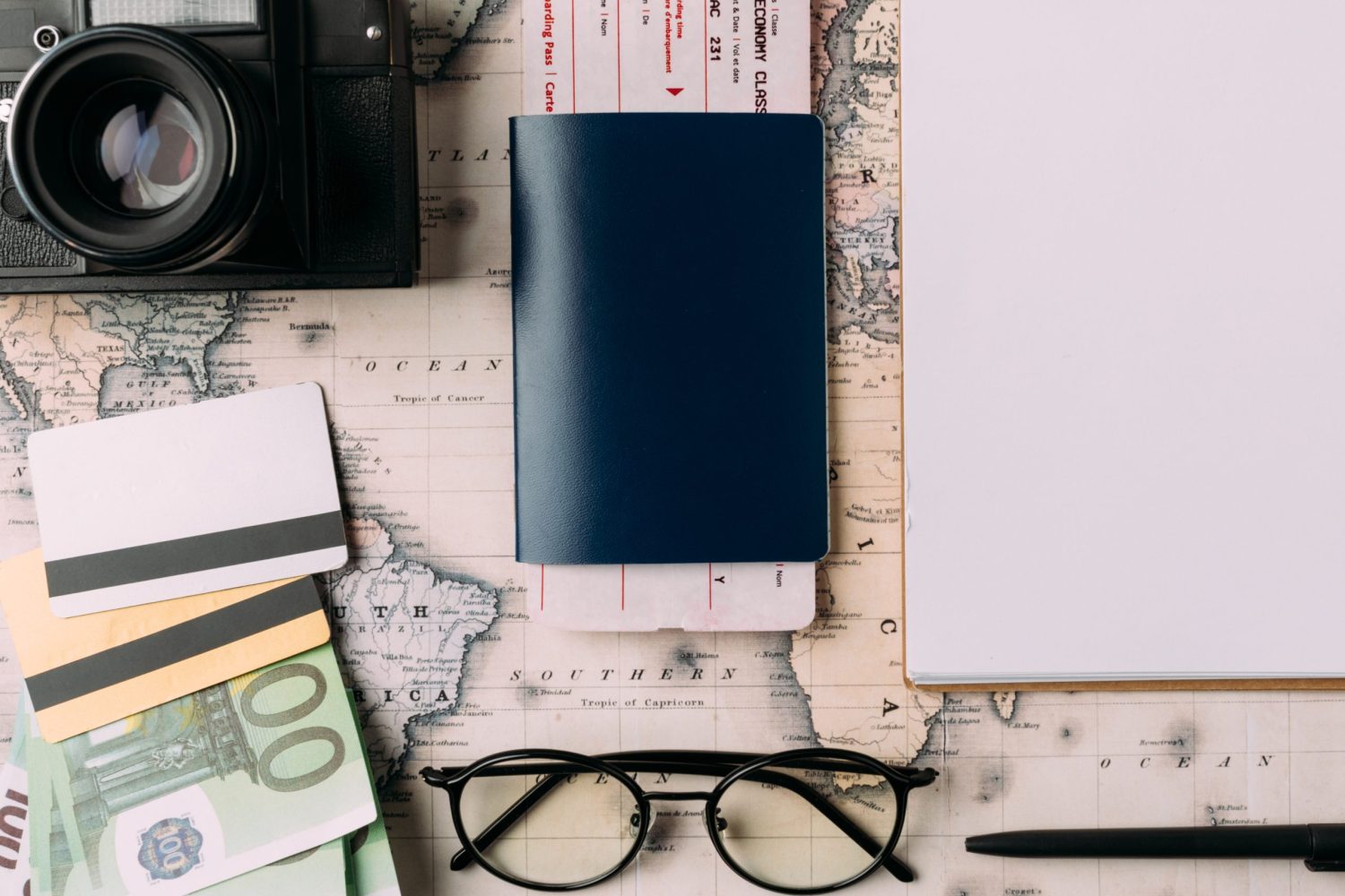 Flat lay of passport with ticket and money with credit cards on a map. tourism concept